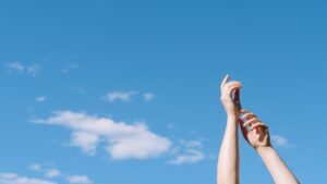 low-angle-hands-raised-up-with-sky-clouds